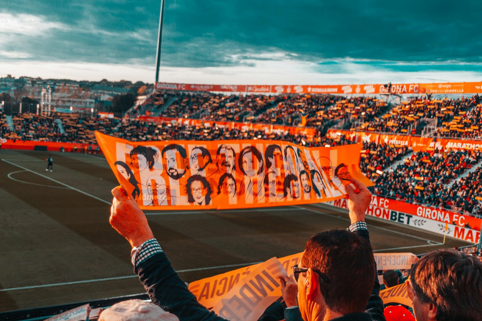 Energetic crowd at Girona FC stadium holding a vibrant banner during a football match.